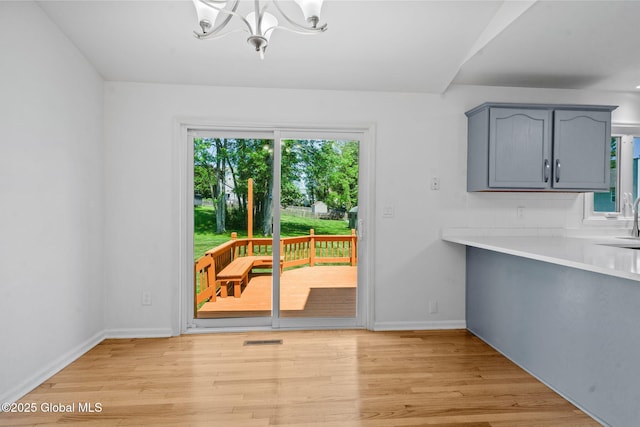 19 Runnel Dr, Colonie, NY 12304 - unfurnished dining area with a chandelier, light wood finished floors, and baseboards
