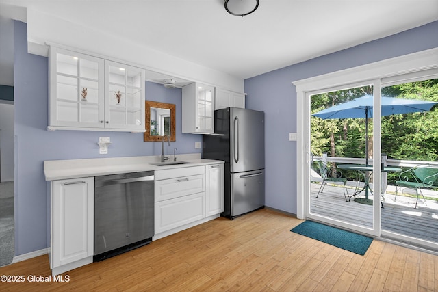 21 Hemlock Dr, Greenfield, NY 12833 - kitchen featuring stainless steel appliances, light wood finished floors, light countertops, white cabinetry, and glass insert cabinets