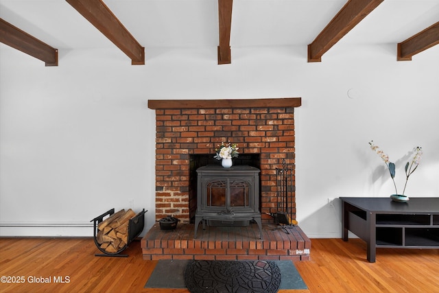 21 Hemlock Dr, Greenfield, NY 12833 - detailed view of a wood stove, wood finished floors, beam ceiling, and a baseboard heating unit