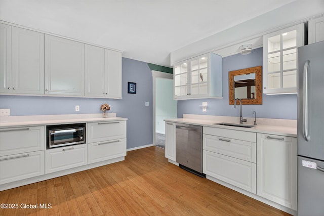 21 Hemlock Dr, Greenfield, NY 12833 - kitchen with stainless steel appliances, light countertops, white cabinets, and light wood finished floors