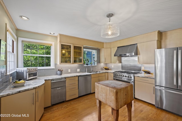 38 Horicon Ave, Glens Falls, NY 12801 - kitchen with appliances with stainless steel finishes, wall chimney exhaust hood, tasteful backsplash, light stone countertops, and light wood finished floors