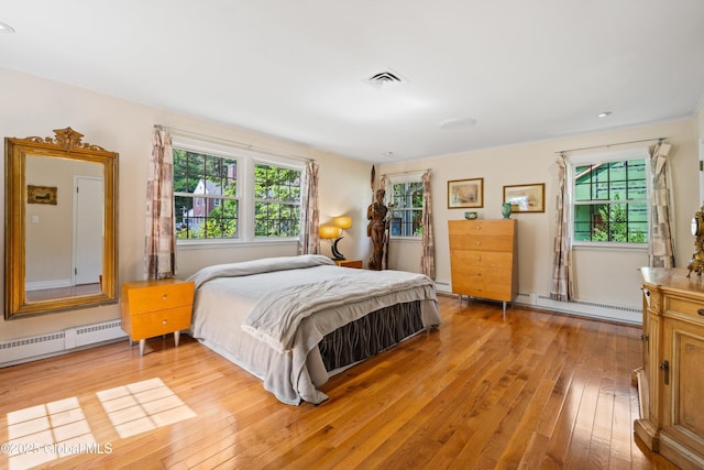 38 Horicon Ave, Glens Falls, NY 12801 - bedroom featuring baseboard heating, light wood-type flooring, a baseboard heating unit, and multiple windows