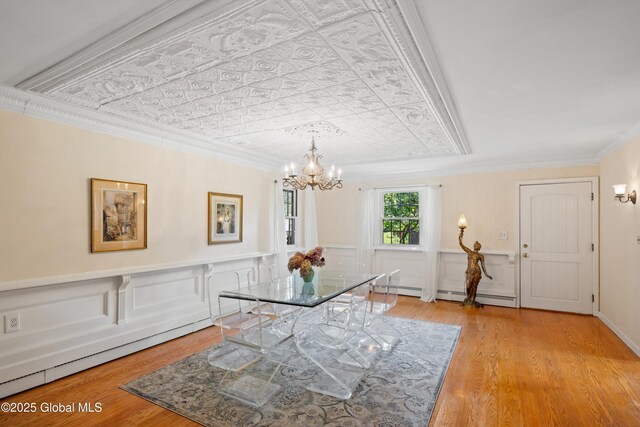 38 Horicon Ave, Glens Falls, NY 12801 - dining area featuring a chandelier, ornamental molding, wood finished floors, baseboard heating, and an ornate ceiling