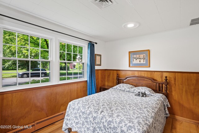 38 Horicon Ave, Glens Falls, NY 12801 - bedroom with a baseboard radiator, wood finished floors, wainscoting, and wood walls