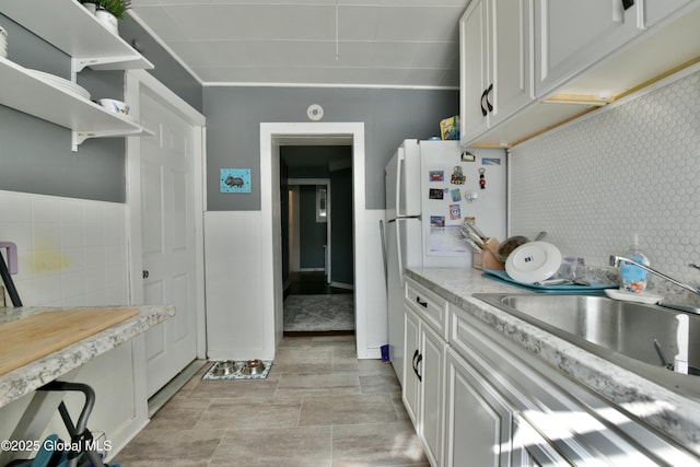 140 3rd St, Troy, NY 12180 - kitchen with light countertops, white cabinets, a sink, open shelves, and a wainscoted wall
