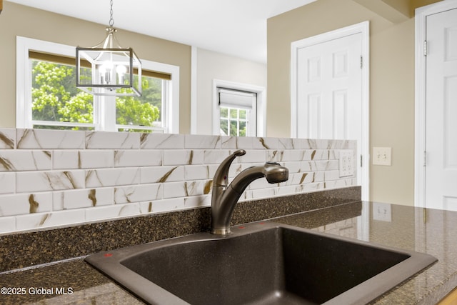 7 Camp Ter, Guilderland, NY 12203 - kitchen view of backsplash, a chandelier, hanging light fixtures, and dark stone counters