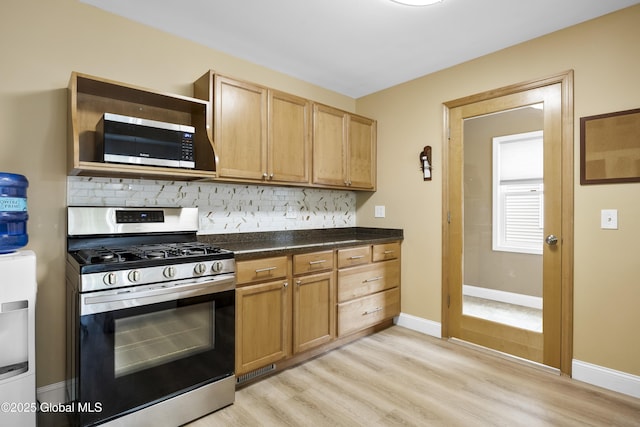 7 Camp Ter, Guilderland, NY 12203 - kitchen with appliances with stainless steel finishes, backsplash, dark countertops, and light wood-type flooring