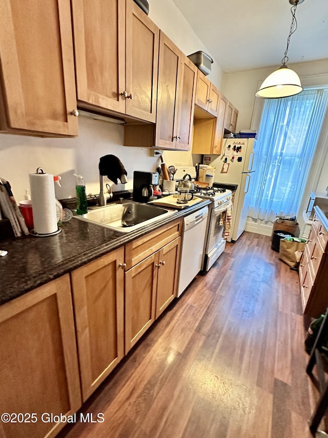 369 Madison Ave, Albany, NY 12210 - kitchen featuring a sink, white appliances, dark wood finished floors, dark countertops, and hanging light fixtures