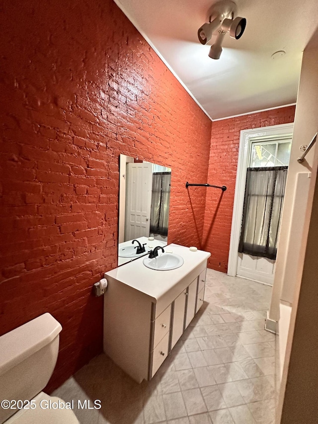 369 Madison Ave, Albany, NY 12210 - bathroom with vanity, toilet, and brick wall