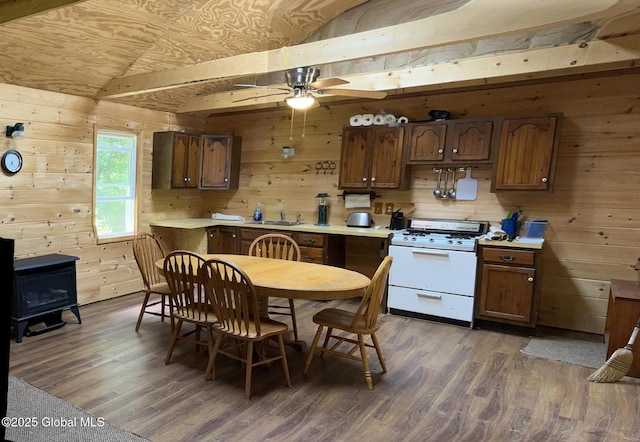 10 W Tucker Rd, Stony Creek, NY 12878 - kitchen featuring white range with gas stovetop, wooden walls, a wood stove, a sink, and light countertops