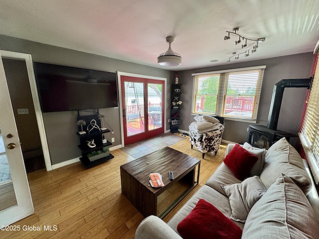 302 Pennsylvania Ave, Johnstown, NY 12095 - living room with a wood stove, baseboards, light wood finished floors, and french doors