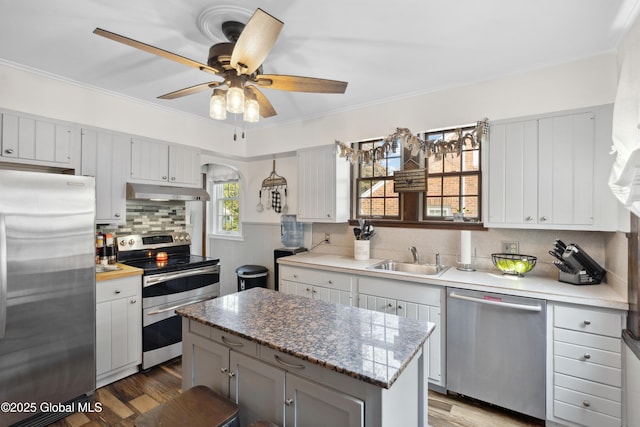 2400 Curry Rd, Schenectady, NY 12303 - kitchen featuring appliances with stainless steel finishes, a sink, wood finished floors, backsplash, and crown molding