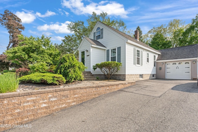2400 Curry Rd, Schenectady, NY 12303 - view of front facade featuring a chimney, asphalt driveway, roof with shingles, a garage, and an outbuilding