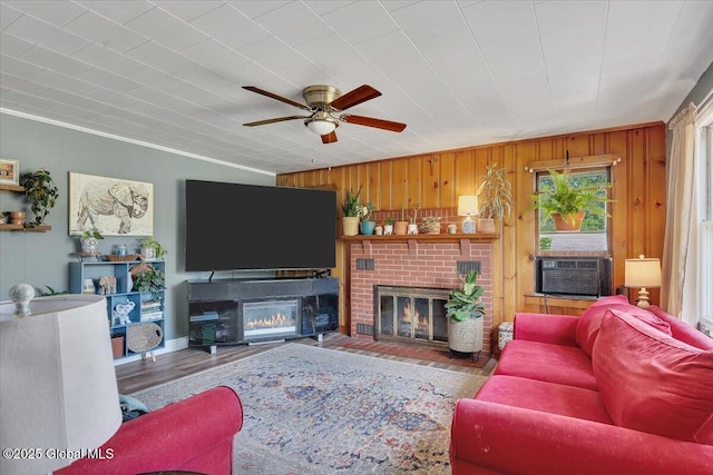 3287 Ny Highway 43, Sand Lake, NY 12018 - living area featuring a brick fireplace, ceiling fan, cooling unit, wood finished floors, and wooden walls
