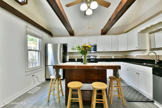 235 Maple Ave, Saratoga Springs, Inside, NY 12866 - kitchen with appliances with stainless steel finishes, light wood-style flooring, white cabinets, and a kitchen breakfast bar
