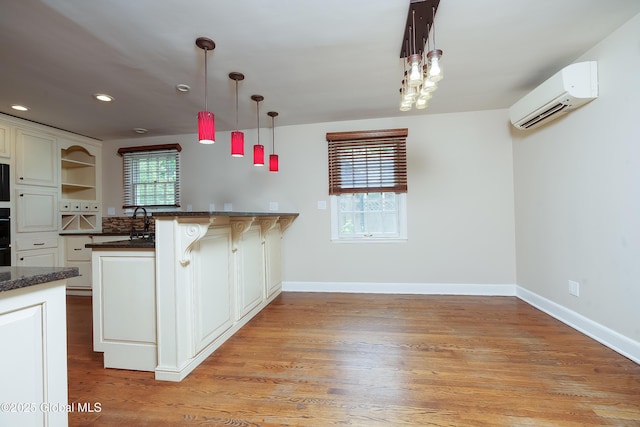 2 Darroch Rd, Bethlehem, NY 12054 - kitchen featuring a wall mounted air conditioner, a breakfast bar area, healthy amount of natural light, decorative light fixtures, and recessed lighting