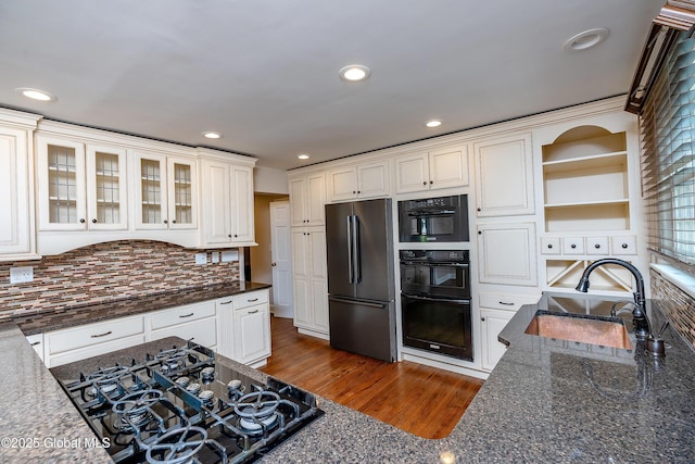 2 Darroch Rd, Bethlehem, NY 12054 - kitchen with black appliances, a sink, dark stone counters, decorative backsplash, and glass insert cabinets