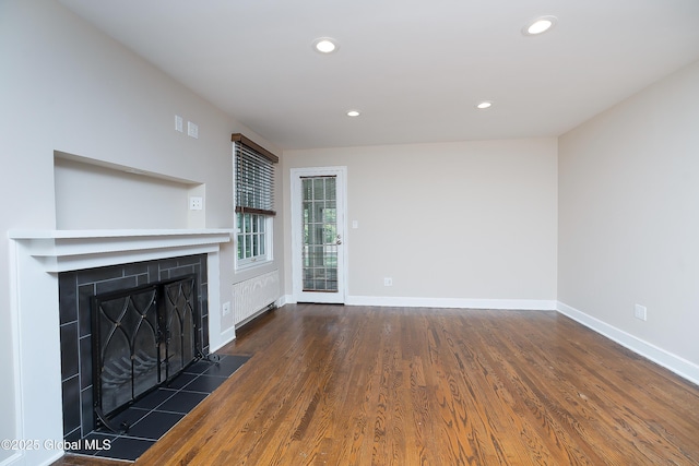 2 Darroch Rd, Bethlehem, NY 12054 - unfurnished living room featuring a tiled fireplace, recessed lighting, wood finished floors, and baseboards