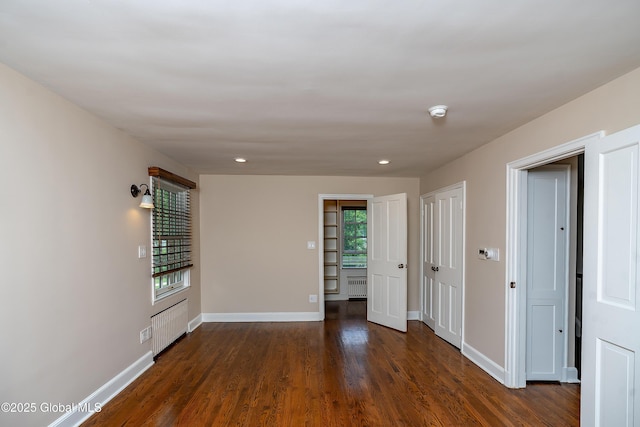 2 Darroch Rd, Bethlehem, NY 12054 - empty room with healthy amount of natural light, baseboards, dark wood-type flooring, radiator heating unit, and recessed lighting