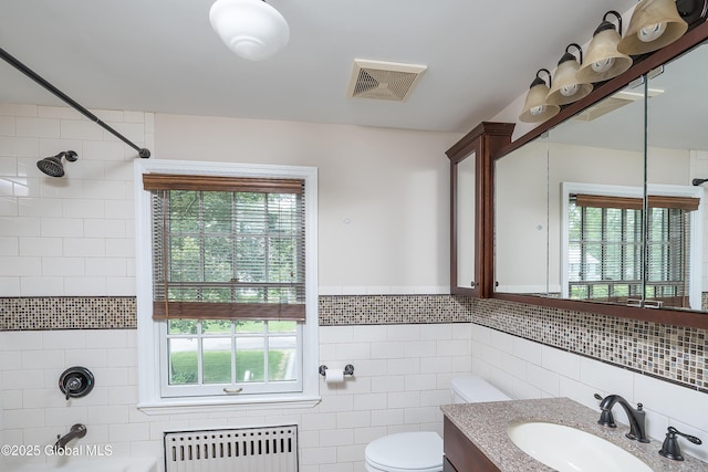 2 Darroch Rd, Bethlehem, NY 12054 - bathroom with radiator, tile walls, vanity, toilet, and plenty of natural light