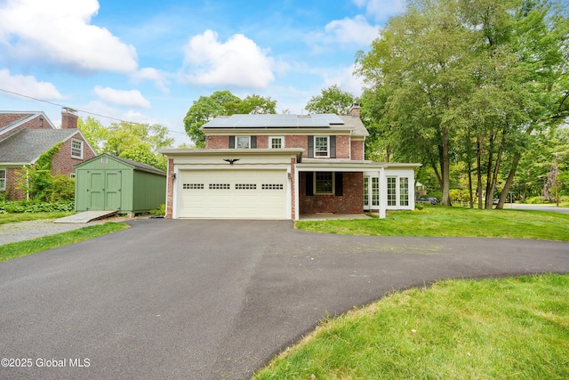 2 Darroch Rd, Bethlehem, NY 12054 - view of front of house with brick siding, asphalt driveway, a front lawn, solar panels, and a garage