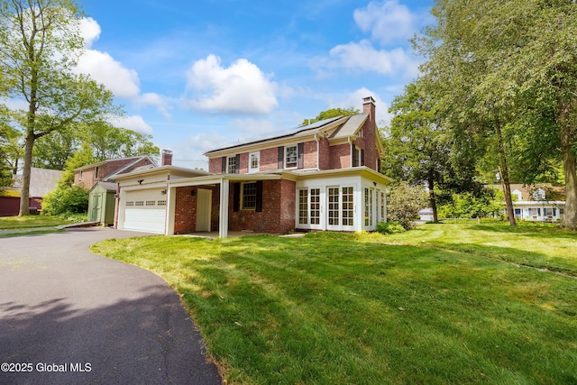 2 Darroch Rd, Bethlehem, NY 12054 - traditional home with brick siding, a chimney, driveway, an attached garage, and a front lawn