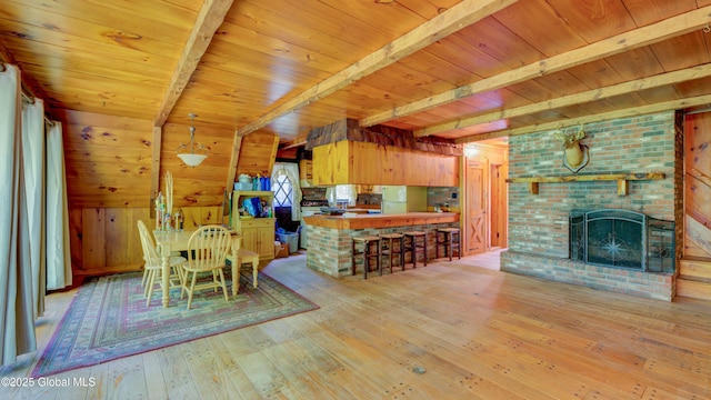824 County Highway 106, Mayfield, NY 12010 - dining space featuring wooden ceiling with exposed beams, hardwood / wood-style flooring, a brick fireplace, and wood walls