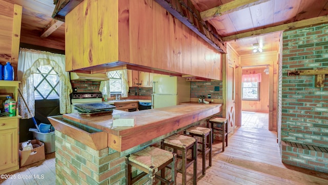 824 County Highway 106, Mayfield, NY 12010 - kitchen featuring freestanding refrigerator, stove, light wood finished floors, under cabinet range hood, and wood ceiling with exposed beams