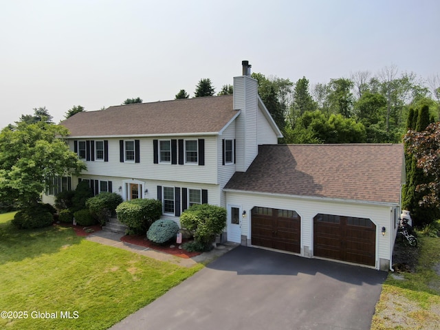 540 Mohawk Dr, Mohawk, NY 12068 - view of front facade with a garage, asphalt driveway, a chimney, a front lawn, and a shingled roof