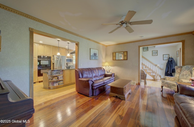 540 Mohawk Dr, Mohawk, NY 12068 - living room with light wood-type flooring, a ceiling fan, crown molding, and stairway