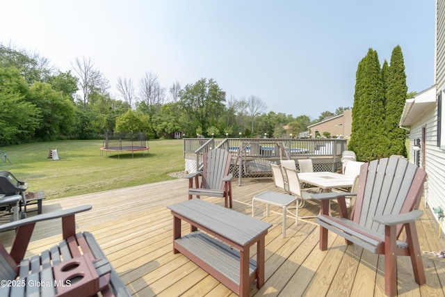 540 Mohawk Dr, Mohawk, NY 12068 - deck featuring a trampoline, outdoor dining space, and a yard