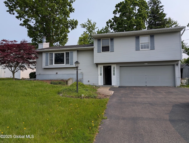 2714 Magnolia St, Endicott, NY 13760 - tri-level home featuring a garage, asphalt driveway, a chimney, and a front lawn