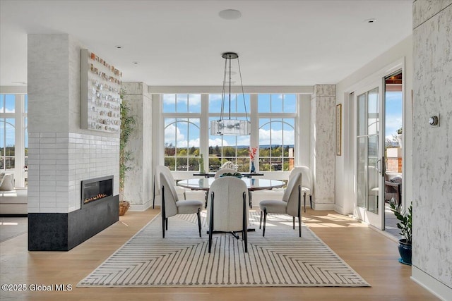 268 Broadway Unit 607, Saratoga Springs, Inside, NY 12866 - dining space featuring wood finished floors, a fireplace, and a chandelier