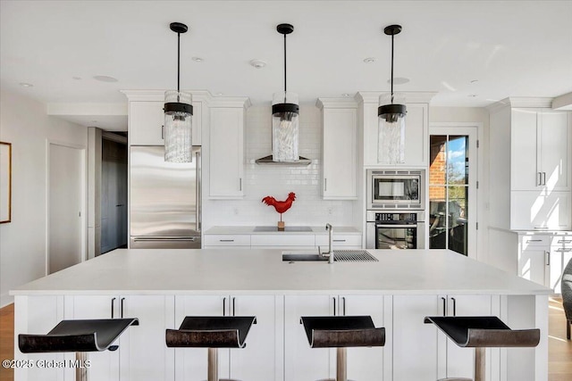 268 Broadway Unit 607, Saratoga Springs, Inside, NY 12866 - kitchen featuring built in appliances, tasteful backsplash, white cabinetry, light countertops, and a kitchen bar