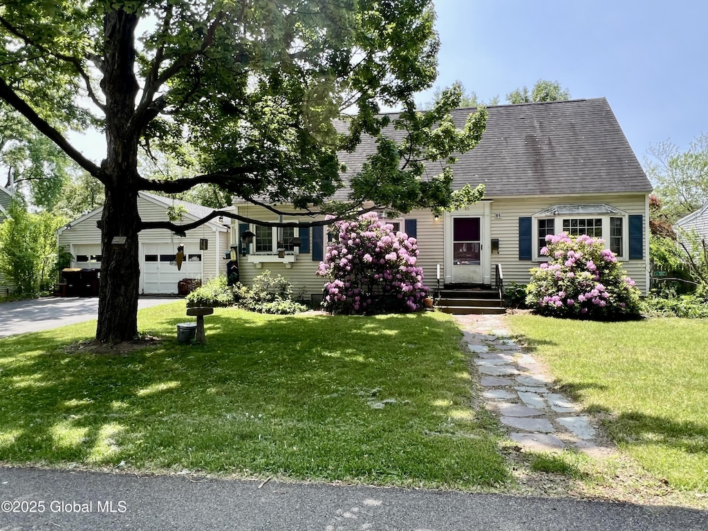 86 Glendale Rd, Colonie, NY 12110 - view of front facade featuring a front yard, a shingled roof, driveway, and a garage