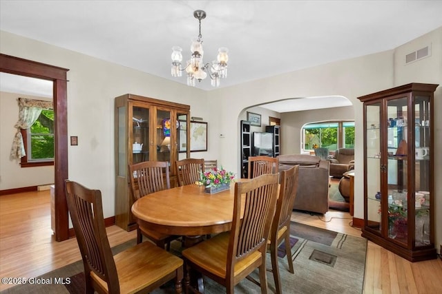 92 Fiddlers Ln, Colonie, NY 12110 - dining area featuring arched walkways, light wood finished floors, a chandelier, and baseboards