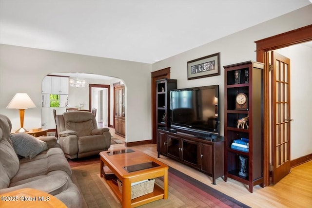 92 Fiddlers Ln, Colonie, NY 12110 - living area featuring arched walkways, a chandelier, light wood-type flooring, and baseboards