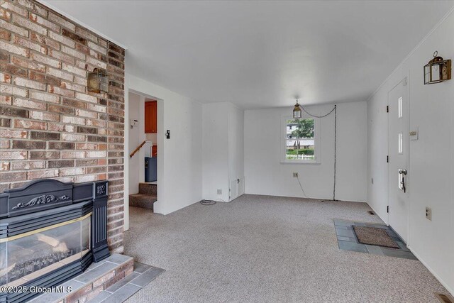327 Sullivan Rd, Schenectady, NY 12304 - unfurnished living room featuring carpet flooring, stairway, and a brick fireplace