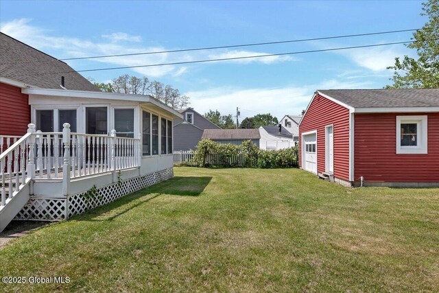 327 Sullivan Rd, Schenectady, NY 12304 - view of grassy yard featuring a sunroom, a detached garage, and a wooden deck