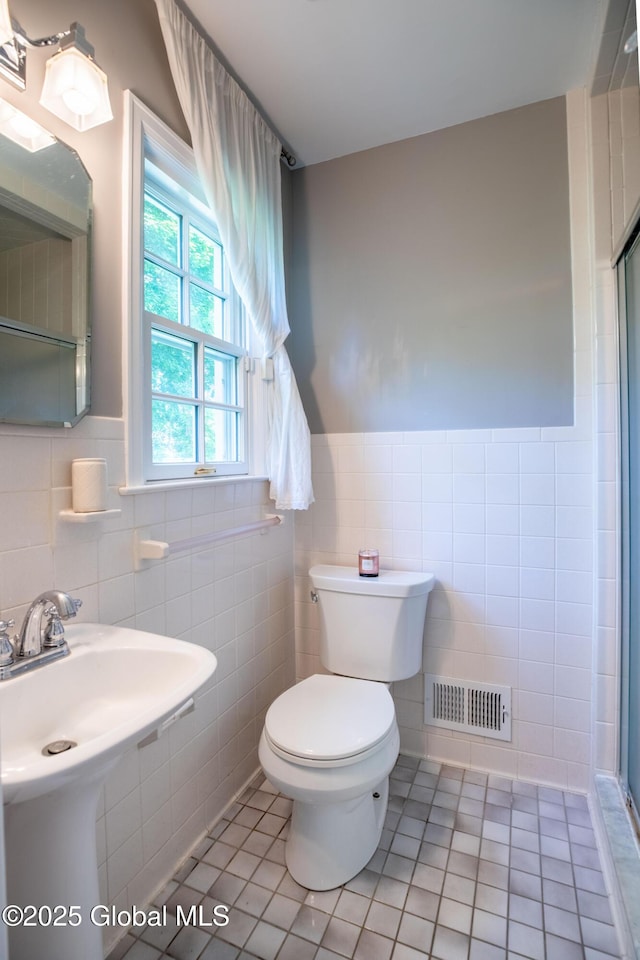 1269 Hawthorn Rd, Niskayuna, NY 12309 - bathroom featuring tile walls, tile patterned floors, a shower stall, and wainscoting