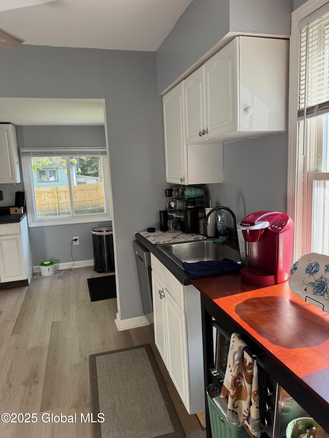 3516 Consaul Rd, Schenectady, NY 12304 - kitchen featuring a sink, dark countertops, white cabinetry, wood finished floors, and stainless steel dishwasher