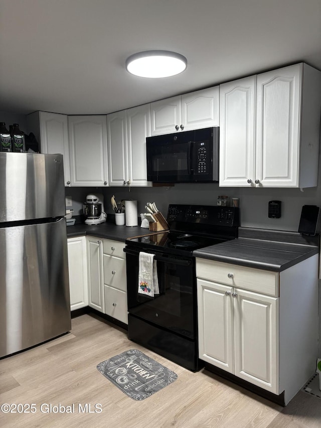 3516 Consaul Rd, Schenectady, NY 12304 - kitchen featuring black appliances, dark countertops, light wood-style flooring, and white cabinetry