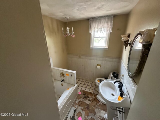 6770 Obrien Rd, Rome, NY 13440 - bathroom featuring toilet, a garden tub, wainscoting, tile patterned floors, and a sink