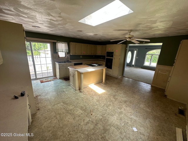 6770 Obrien Rd, Rome, NY 13440 - kitchen featuring a kitchen island, a skylight, ceiling fan, cream cabinets, and light flooring