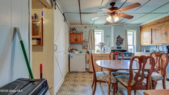 16 Caroline St, Amsterdam, NY 12010 - kitchen with gas range, a barn door, fridge, and a ceiling fan
