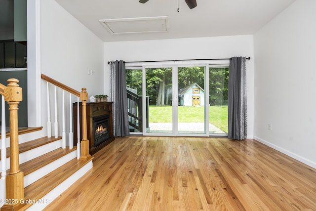 44 St Jude Ln, Glenville, NY 12302 - unfurnished living room featuring light wood-style flooring, ceiling fan, a glass covered fireplace, attic access, and baseboards
