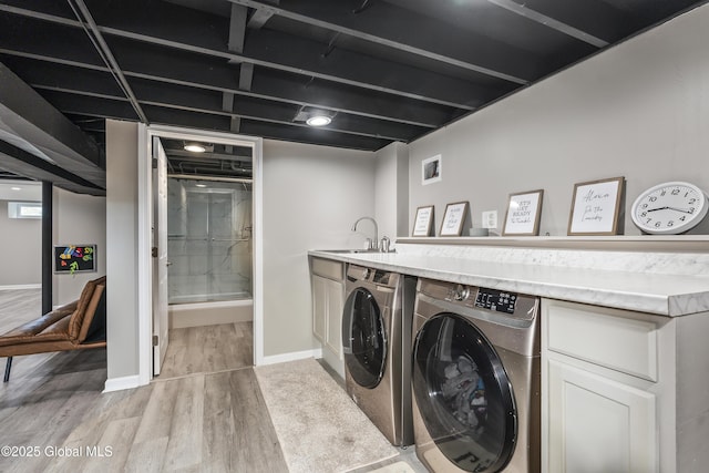 44 St Jude Ln, Glenville, NY 12302 - laundry room with independent washer and dryer, light wood-type flooring, baseboards, and cabinet space