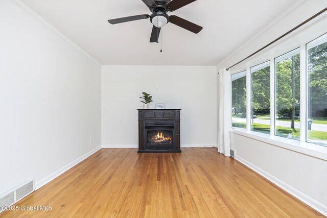 44 St Jude Ln, Glenville, NY 12302 - unfurnished living room with plenty of natural light, crown molding, light wood finished floors, a glass covered fireplace, and baseboards