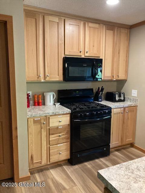 841 Battle Hill Rd, Hague, NY 12836 - kitchen with black appliances, light wood-style floors, light countertops, and light brown cabinetry