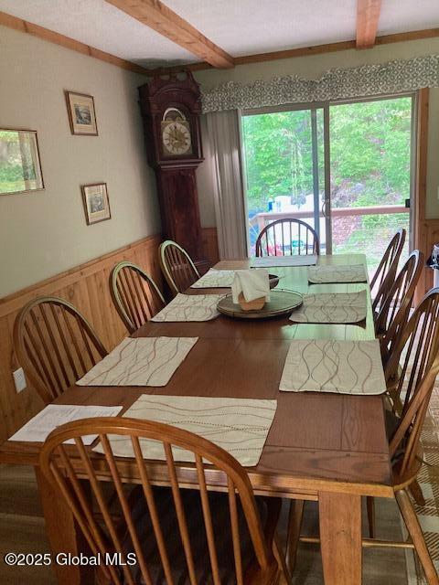 841 Battle Hill Rd, Hague, NY 12836 - dining area featuring beam ceiling, healthy amount of natural light, a wainscoted wall, wood finished floors, and wood walls
